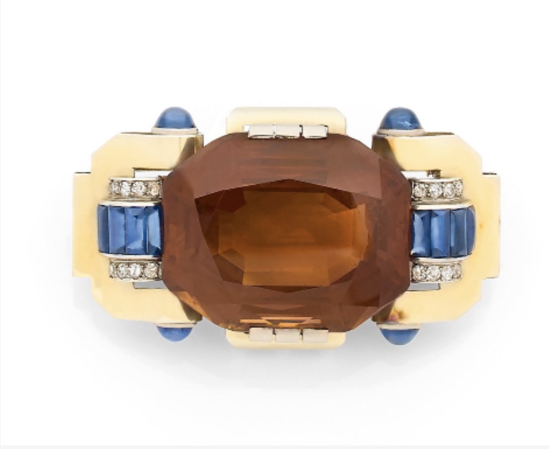 13 Grande broche en or ornée d'un quartz fumé épaulé de rouleaux de saphirs, de diamants et de saphirs cabochons