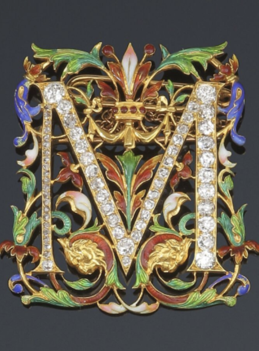 44 Lot 44 : Broche en or découpé d'un M serti de diamants dans un entourage fleuris émaillés.
